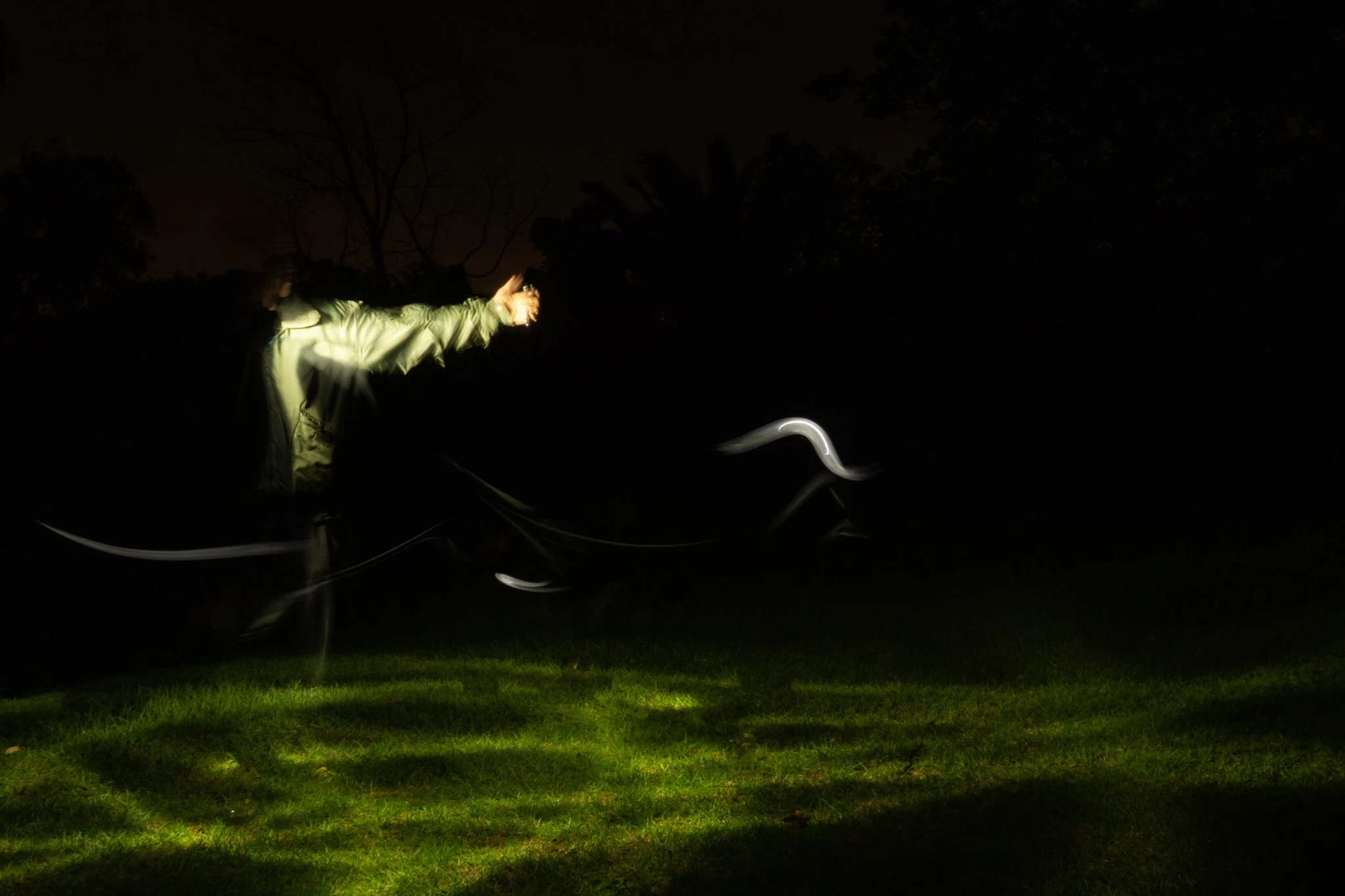 Long exposure figure reaching through darkness